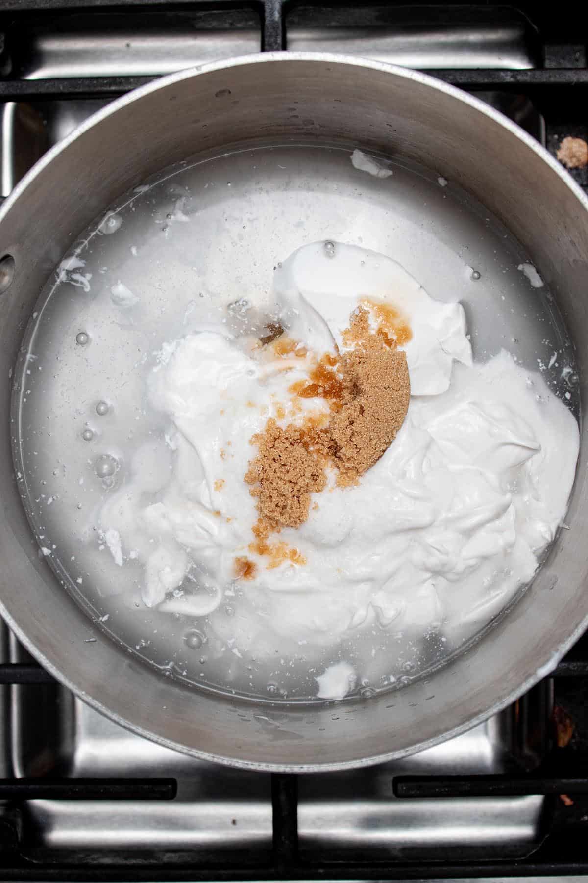 A small pot with water, coconut milk, brown sugar and salt.
