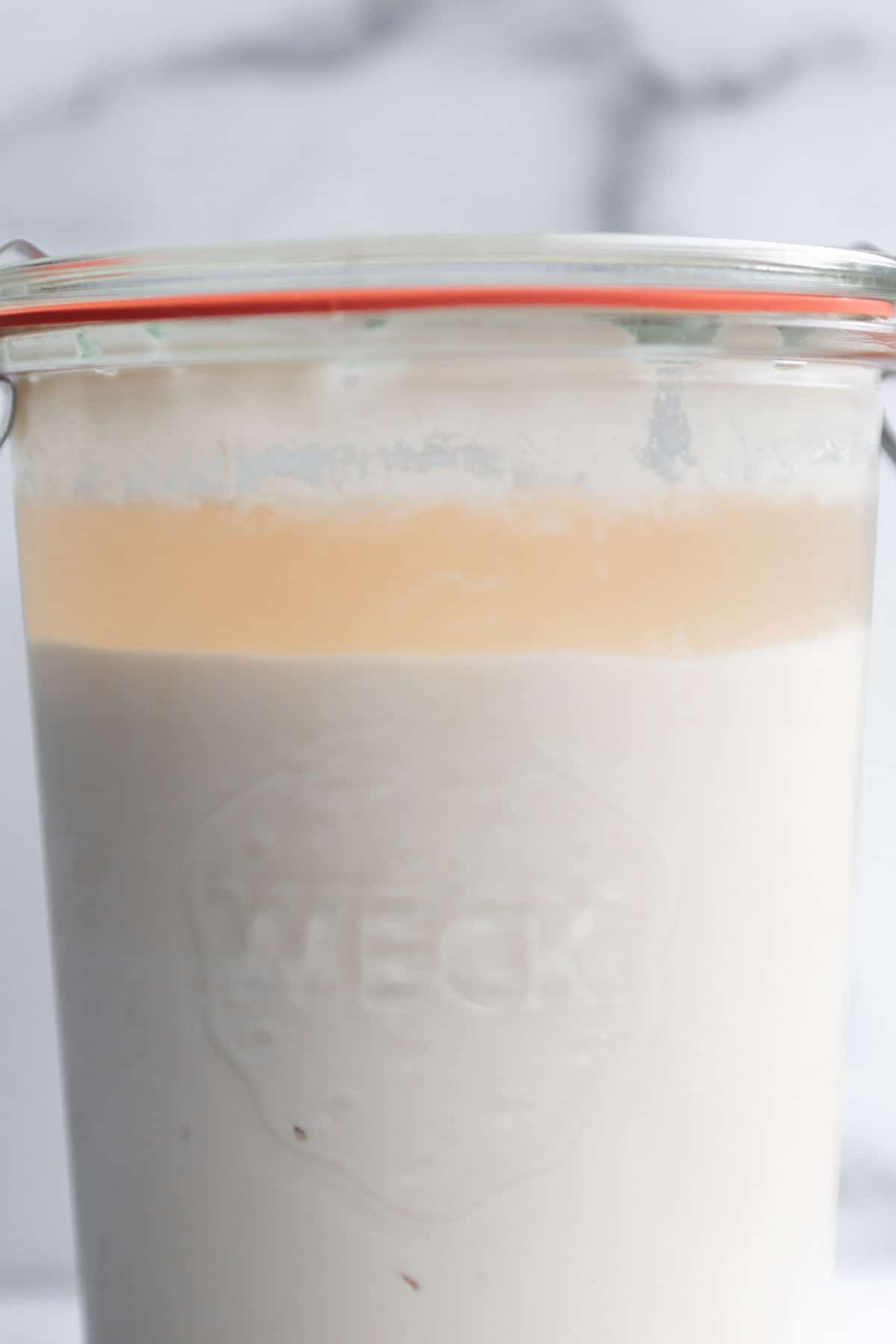 A weck jar with a sourdough starter and a layer of liquid on top.