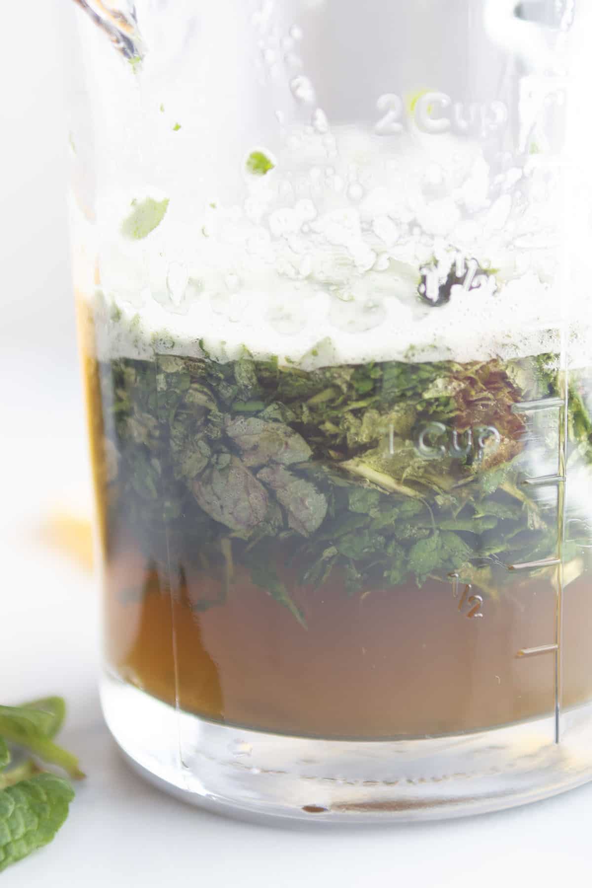 A glass jar with mint and water.