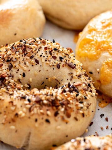Bagels with everything topping and one with cheddar cheese.