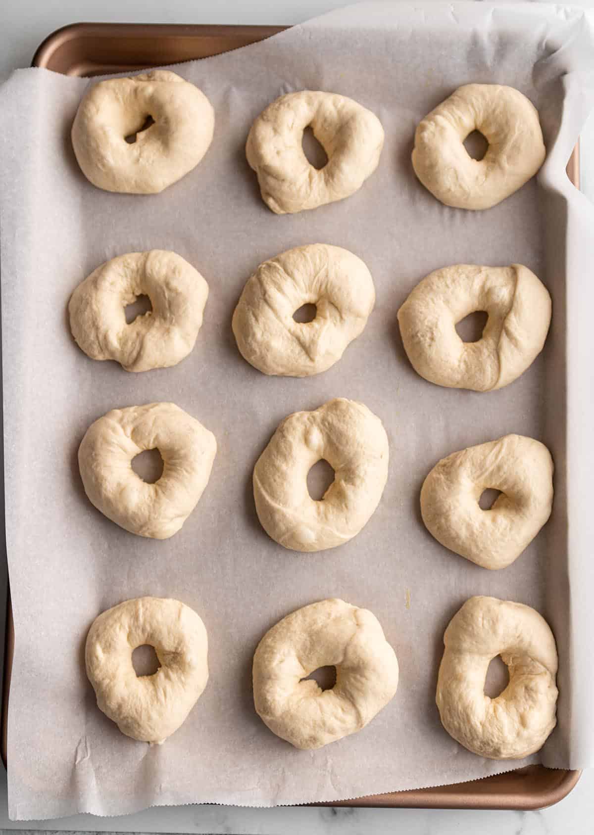 12 bagel rings on a baking sheet.