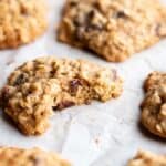 Oatmeal cookie with a bite taken out on a baking sheet