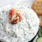 A bowl of fresh crab dip with cream cheese and a lump of fresh crab meat on top.