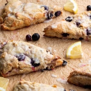 Scones that blueberries and a lemon glaze with fresh lemons and blueberries.