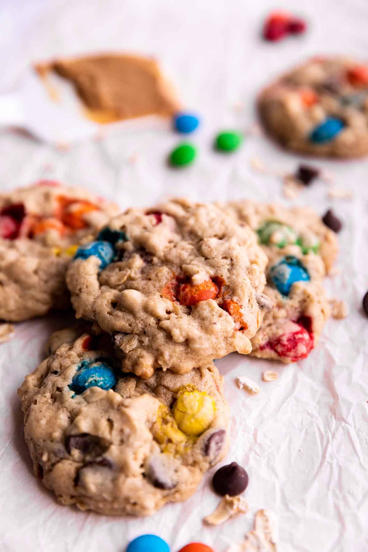 Cookies stacked on each other with M&M's, Oatmeal and a spatula with peanut butter.