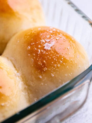 Homemade dinner roll in a glass pan with sea salt on top.